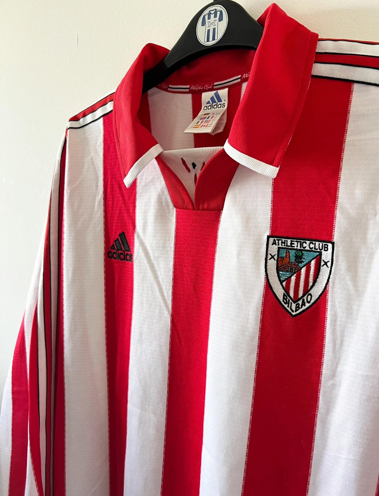 Maillot de foot vintage domicile rouge et blanc de l'Athletic Bilbao de la saison 1999/2001. On peut retrouver l'équipementier Adidas. Il s'agit d'un maillot authentique d'époque issu du stock pro.