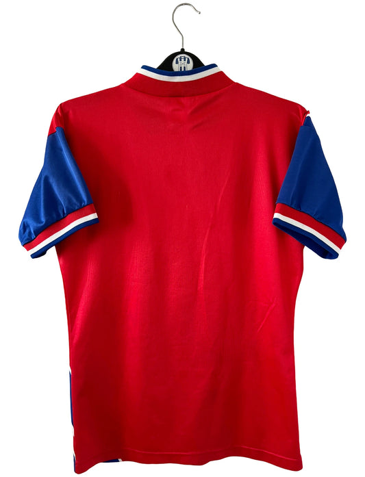 Maillot de foot vintage domicile rouge et bleu du Bayern Munich de la saison 1993-1994. On peut retrouver l'équipementier Adidas et le sponsor Opel. Il s'agit d'un maillot authentique d'époque.