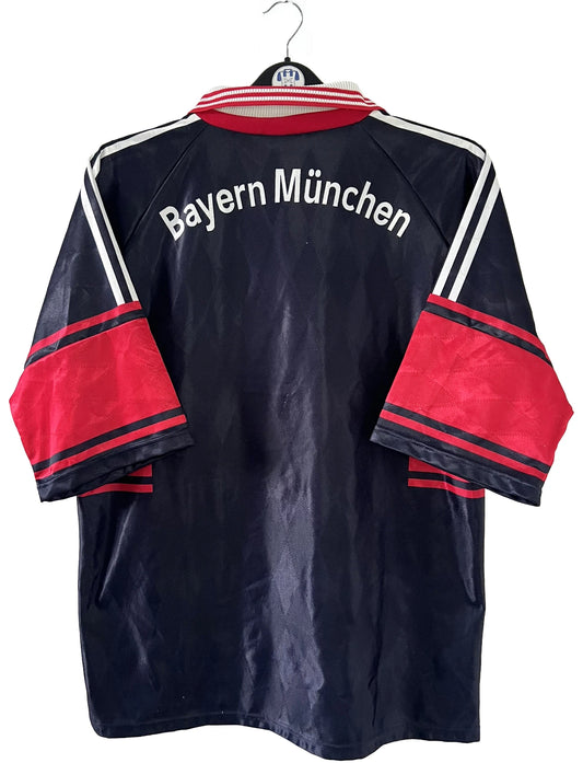 Maillot de foot vintage domicile noir du bayern munich de la saison 1997-1998. On peut retrouver l'équipementier Adidas et le sponsor Opel. Il s'agit d'un maillot authentique d'époque.