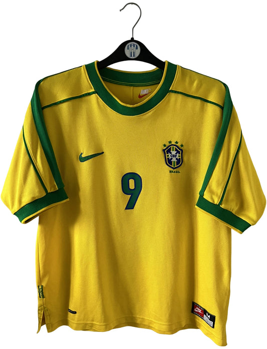 Maillot de foot vintage domicile jaune du Brésil 1998. On peut retrouver l'équipementier Nike. Le maillot est floqué du numéro 9 Ronaldo. Il s'agit d'un maillot authentique d'époque.