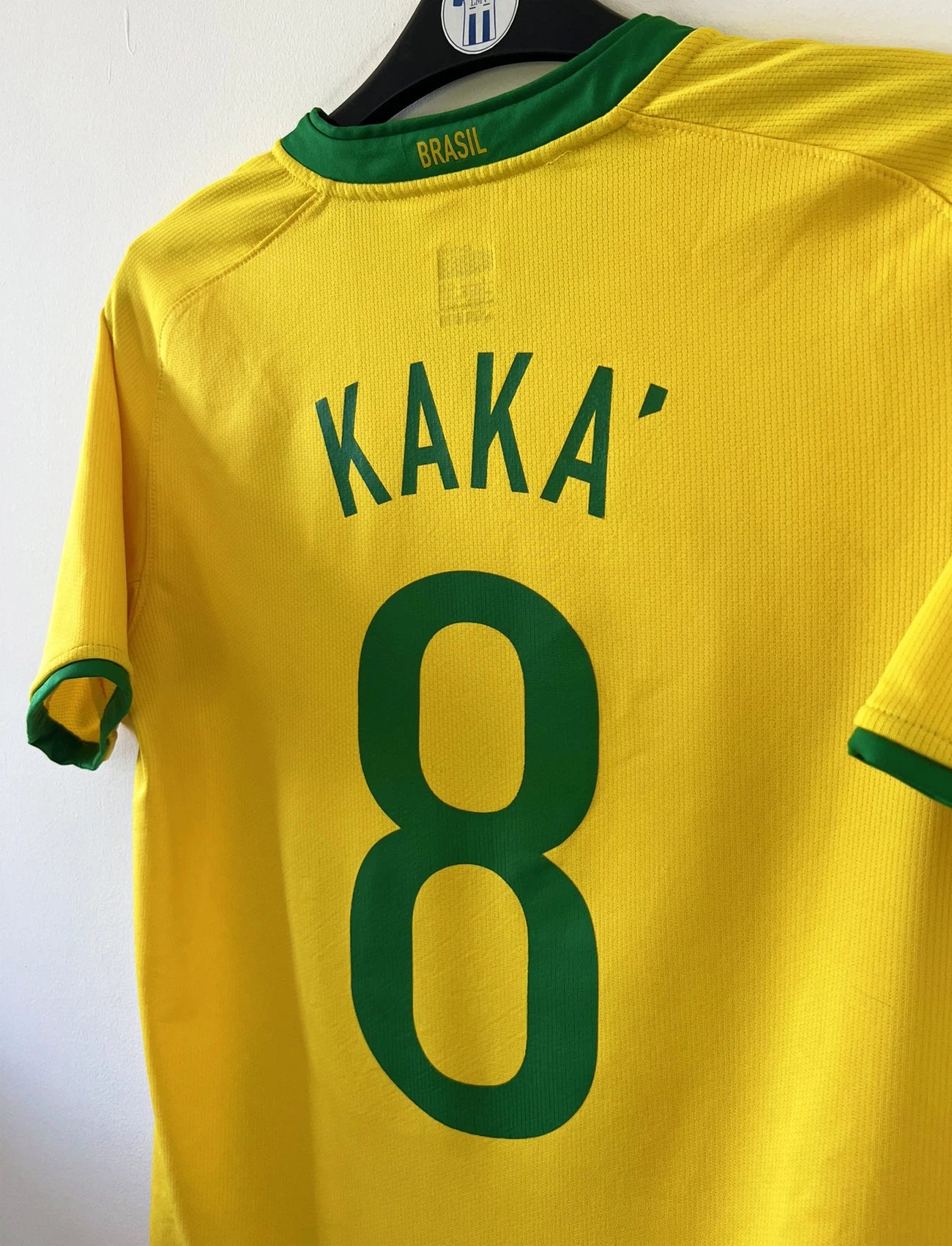 Maillot de foot vintage domicile du Brésil de la saison 2008/2010. On peut retrouver l'équipementier Nike. Le maillot est floqué du numéro 8 Kaka. Il s'agit d'un maillot authentique d'époque comportant les numéros 258949-703.