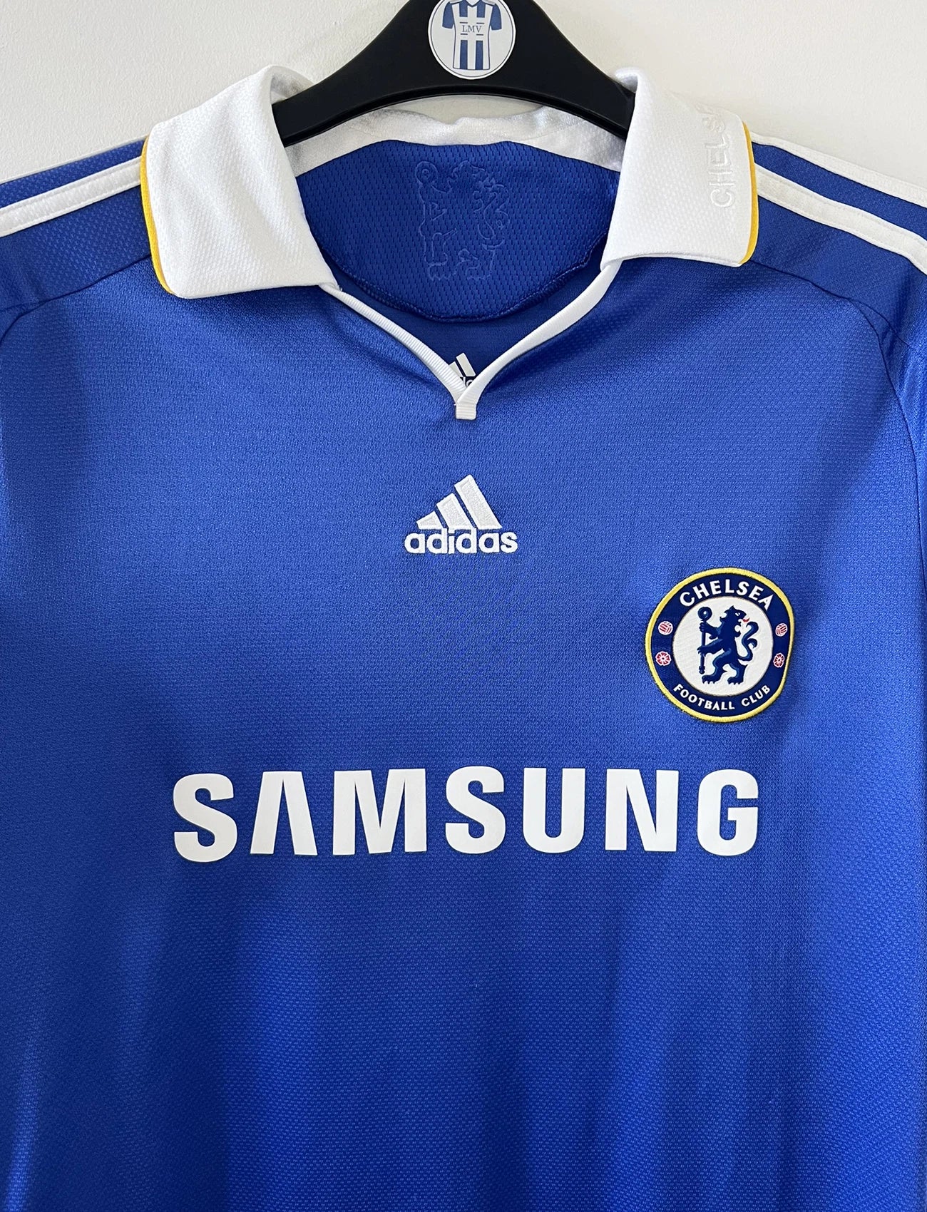 Maillot de foot vintage domicile bleu de chelsea de la saison 2008/2009. On peut retrouver l'équipementier adidas et le sponsor Samsung. Le maillot est floqué du numéro 11 Didier Drogba. Il s'agit d'un maillot authentique d'époque comportant le numéro 656133