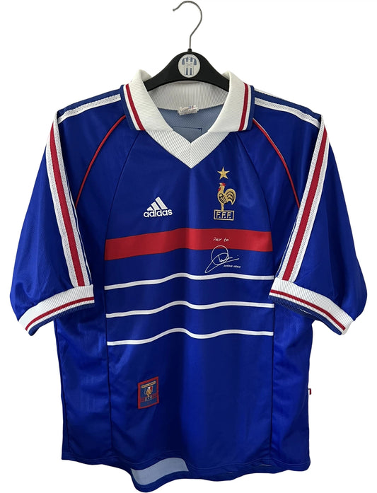 Maillot foot vintage domicile equipe de france 1998 bleu blanc et rouge. On peut retrouver l'équipementier adidas. Le maillot est floqué du numéro 10 Zinedine Zidane. Il s'agit d'un maillot authentique d'époque avec la signature de Zidane en sérigraphié.