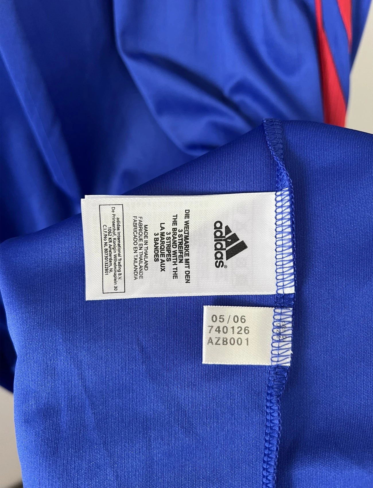 Maillot de foot vintage domicile bleu, blanc et rouge de l'équipe de france 2006. On peut retrouver l'équipementier adidas. Le maillot est floqué du numéro 11 Sylvain Wiltord. Il s'agit d'un maillot authentique d'époque comportant l'étiquette 740126