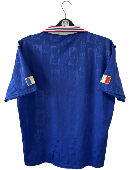 Maillot de foot vintage domicile bleu de l'équipe de france 1996. On peut retrouver l'équipementier Adidas. Il s'agit d'un maillot authentique d'époque.