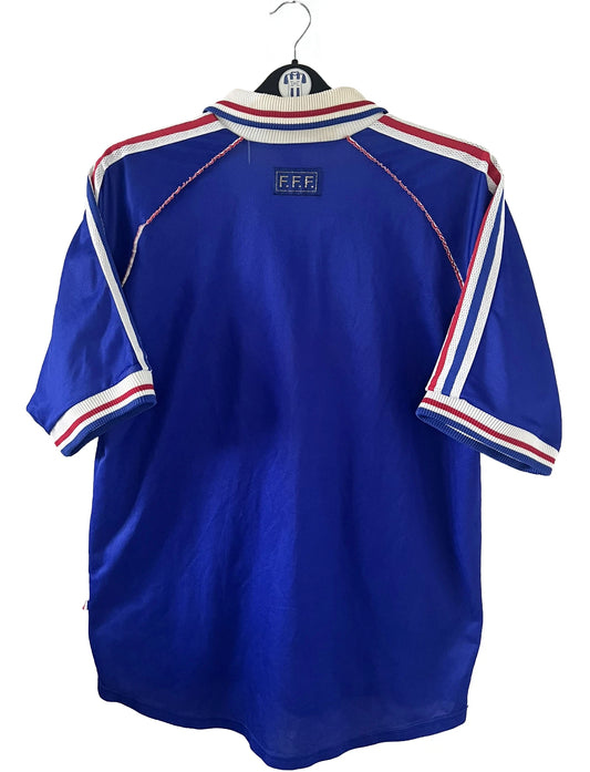 Maillot de foot vintage bleu, blanc et rouge de l'équipe de france 1998. On peut retrouver l'équipementier adidas. Il s'agit d'un maillot authentique édité avant la finale de la coupe du monde car celui-ci ne possède pas l'étoile. Le maillot est floqué du numéro 10 Zidane
