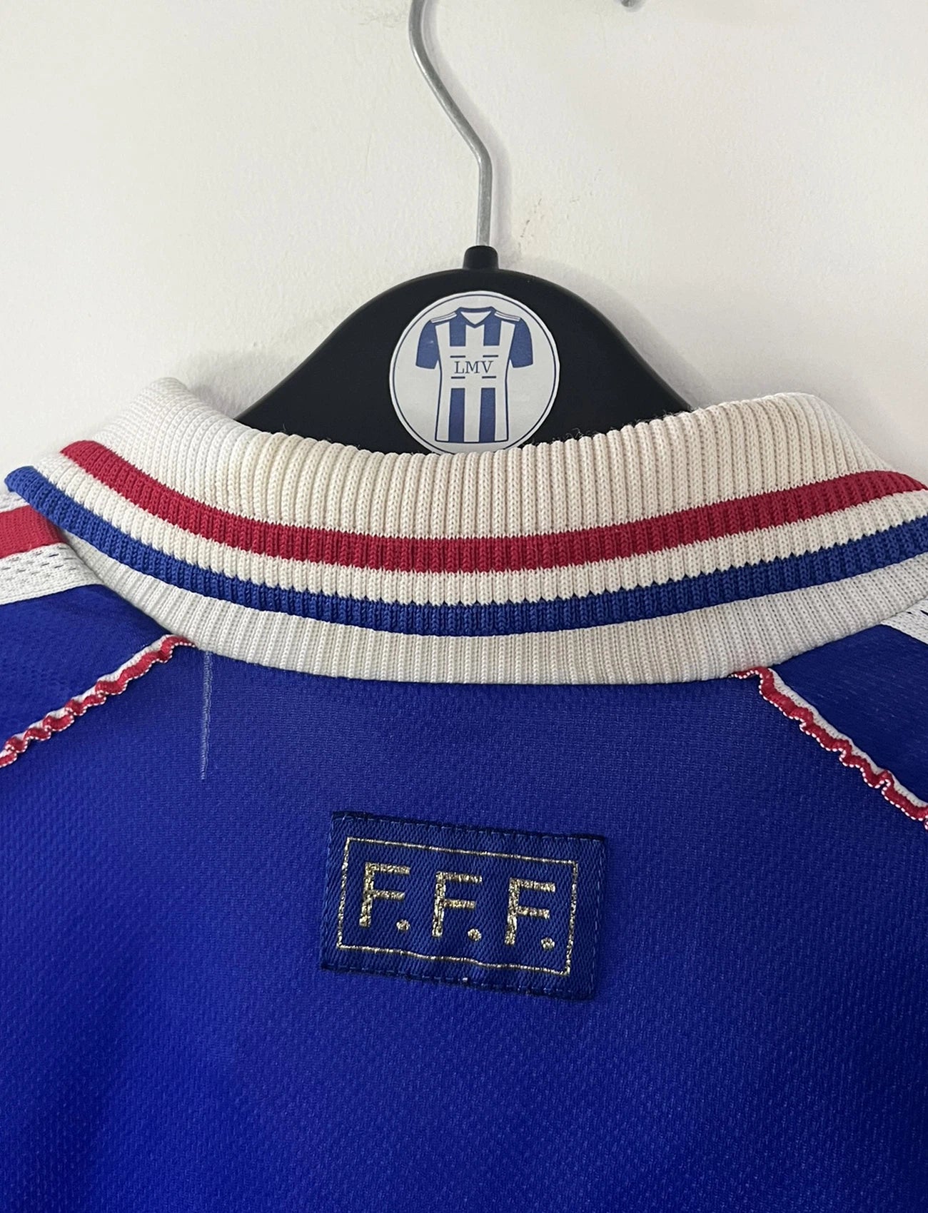 Maillot de foot vintage bleu, blanc et rouge de l'équipe de france 1998. On peut retrouver l'équipementier adidas. Il s'agit d'un maillot authentique édité avant la finale de la coupe du monde car celui-ci ne possède pas l'étoile. Le maillot est floqué du numéro 10 Zidane