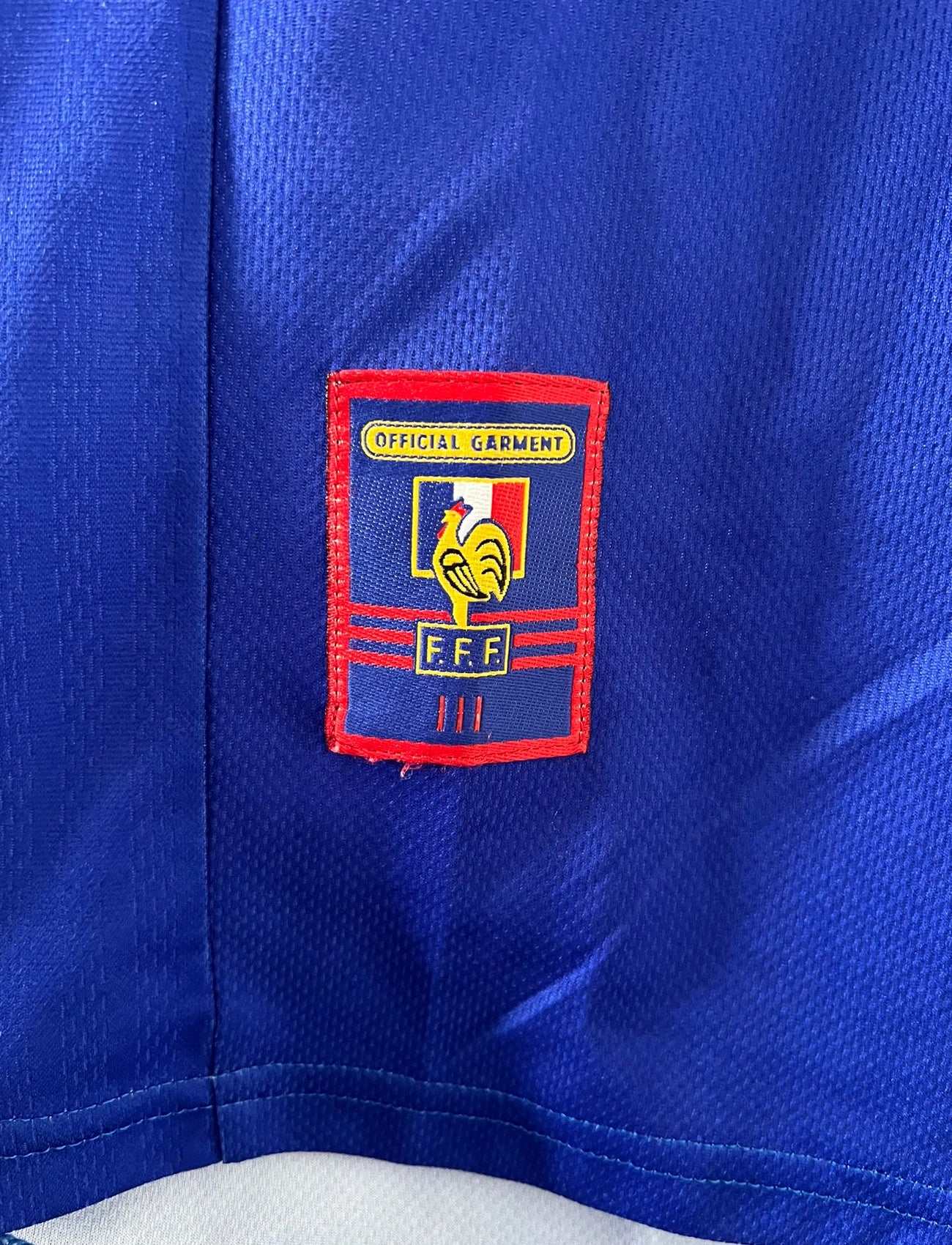 Maillot de foot vintage domicile bleu blanc et rouge de l'équipe de france 1998. On peut retrouver l'équipementier Adidas. Le maillot est floqué du numéro 10 Zinedine Zidane. Il s'agit d'un maillot authentique d'époque.