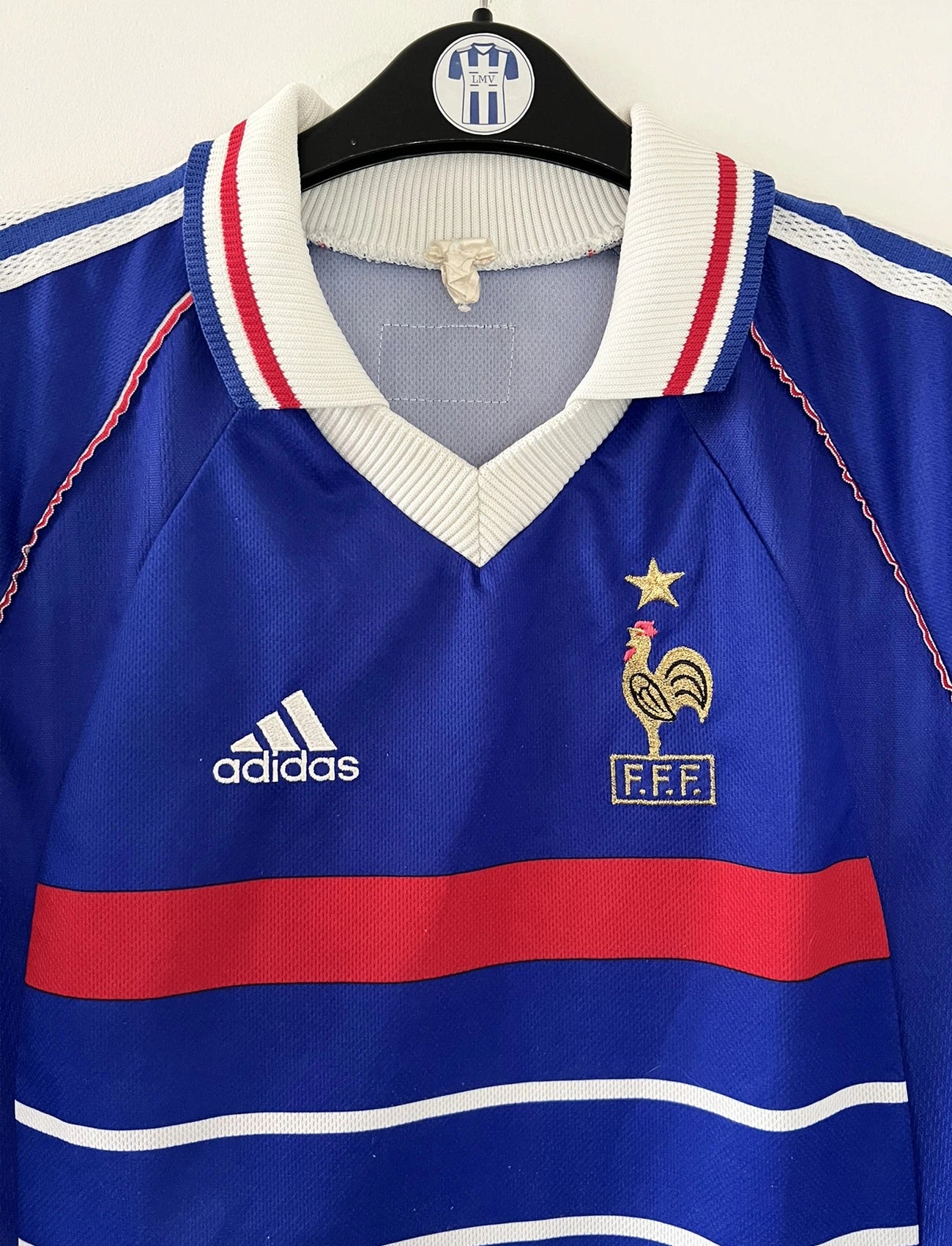 Maillot de foot vintage domicile bleu de l'Equipe de France 1998. On peut retrouver l'équipementier Adidas. Le maillot est floqué Zinedine Zidane. Il s'agit d'un maillot authentique d'époque.