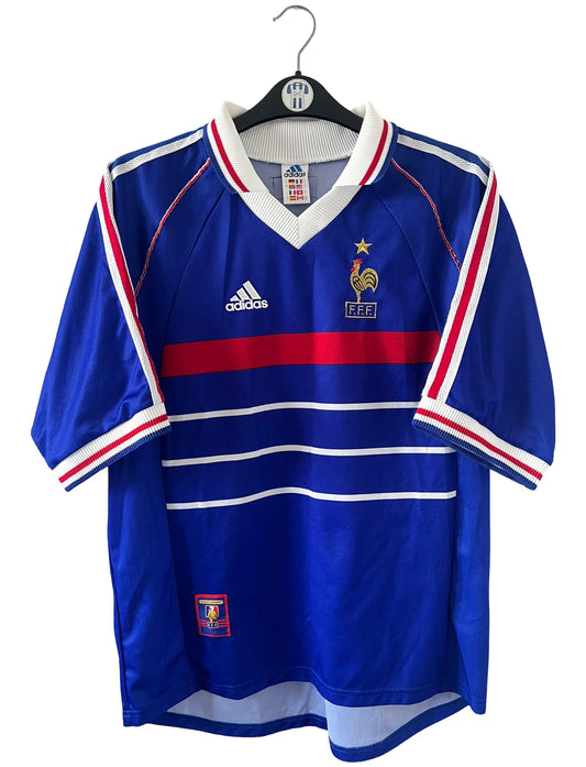 Maillot de foot vintage domicile bleu de l'Equipe de France 1998. On peut retrouver l'équipementier Adidas. Le maillot est floqué du numéro 10 Zidane. Il s'agit d'un maillot authentique d'époque.