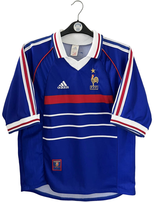 Maillot foot vintage domicile equipe de france 1998 bleu blanc et rouge. On peut retrouver l'équipementier adidas. Le maillot est floqué du numéro 10 Zinedine Zidane. Il s'agit d'un maillot authentique d'époque vendu avec son short d'époque.