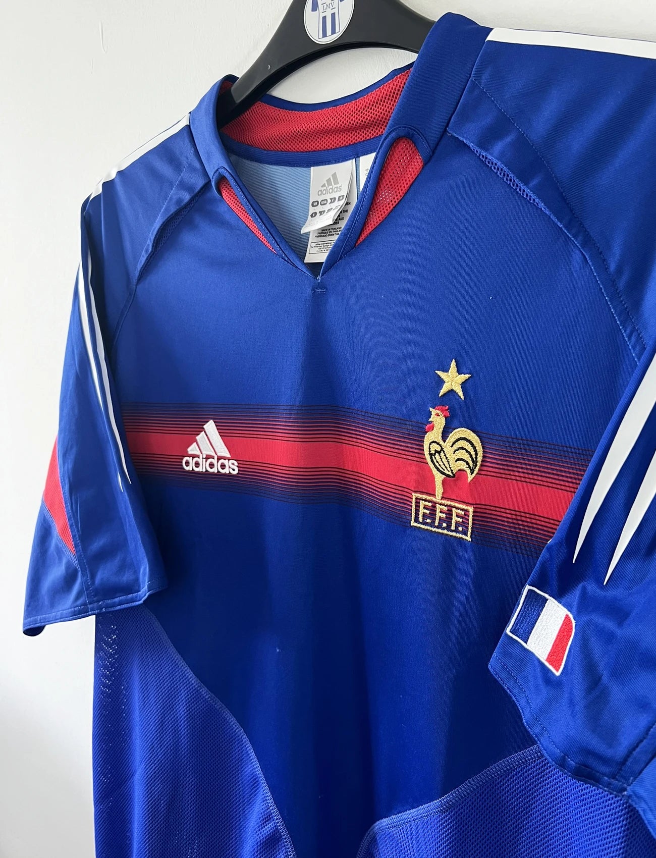 Maillot de foot vintage domicile de l'équipe de france 2004/2006. On peut retrouver l'équipementier adidas. Le maillot est floqué du numéro 10 Zinedine Zidane. Il s'agit d'un maillot authentique d'époque comportant l'étiquette 600222.