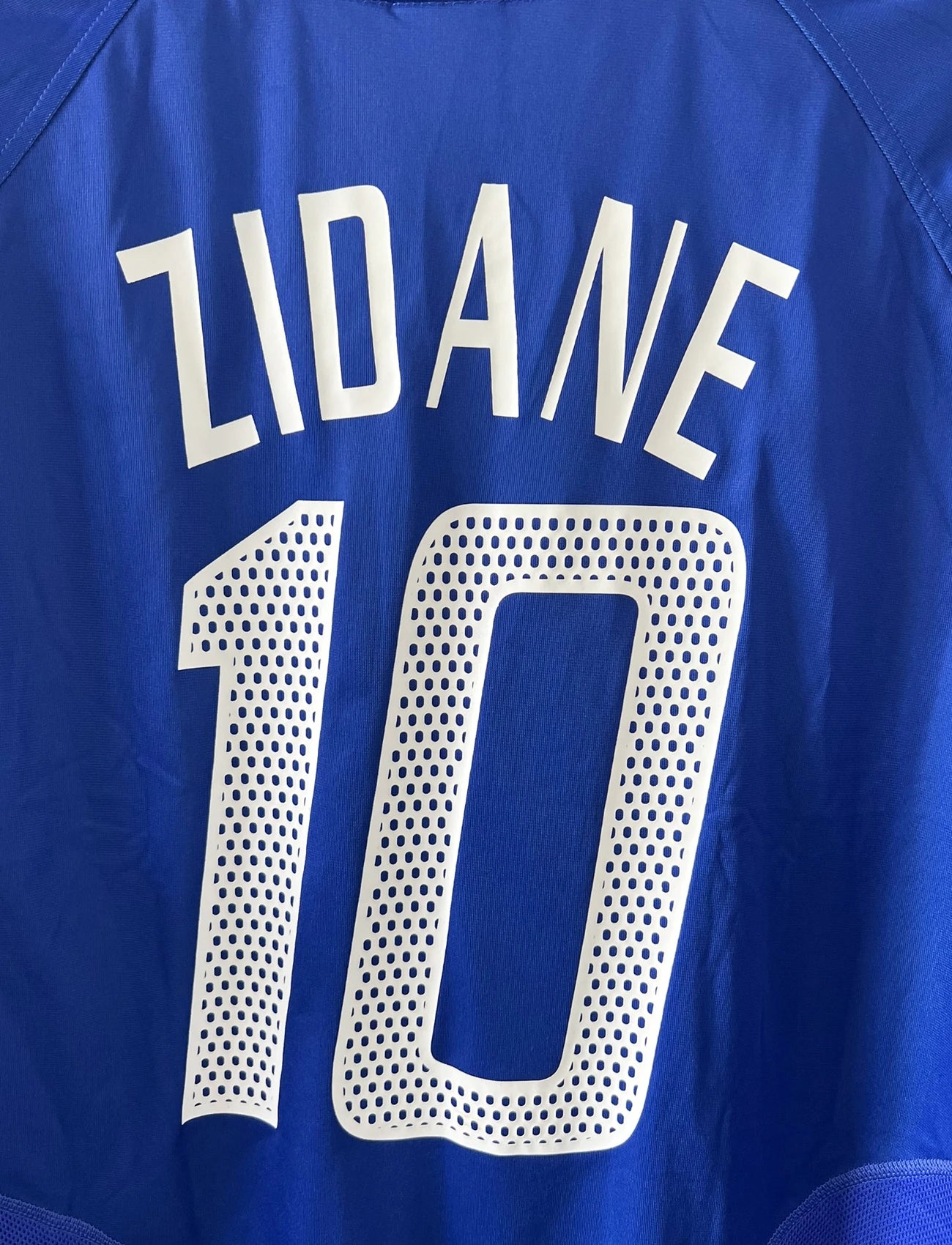 Maillot de foot vintage domicile de l'équipe de france 2004/2006. On peut retrouver l'équipementier adidas. Le maillot est floqué du numéro 10 Zinedine Zidane. Il s'agit d'un maillot authentique d'époque comportant l'étiquette 600222.