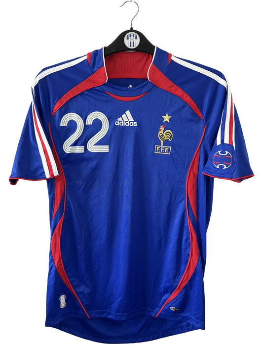 Maillot de foot vintage domicile de l'équipe de france 2006. On peut retrouver l'équipementier adidas. Le maillot est floqué du numéro 22 Franck Ribery. Il s'agit d'un maillot authentique d'époque comportant les numéros 740126