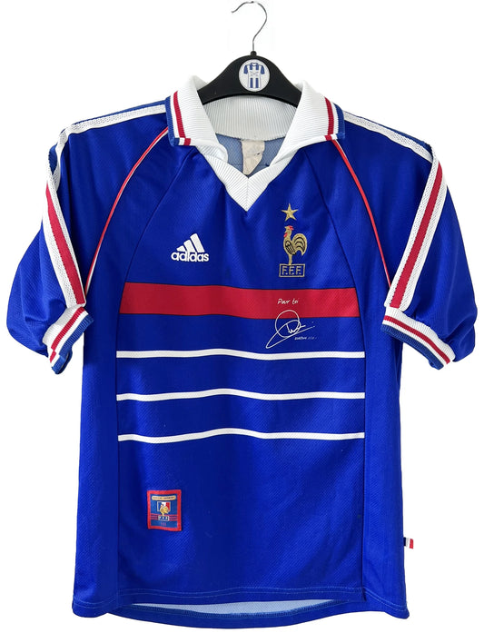 Maillot de foot vintage domicile bleu blanc et rouge de l'équipe de france lors de la coupe du monde 1998. On peut retrouver l'équipementier adidas. Le maillot est floqué du numéro 10 zinedine zidane. Il s'agit d'un maillot authentique d'époque.