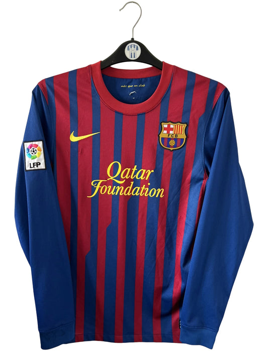 Maillot de foot vintage domicile rouge et bleu du FC Barcelone 2011/2012. On peut retrouver l'équipementier Nike et le sponsor Qatar Foundation. Le maillot est floqué du numéro 10 Lionel Messi. Il s'agit d'un maillot authentique d'époque