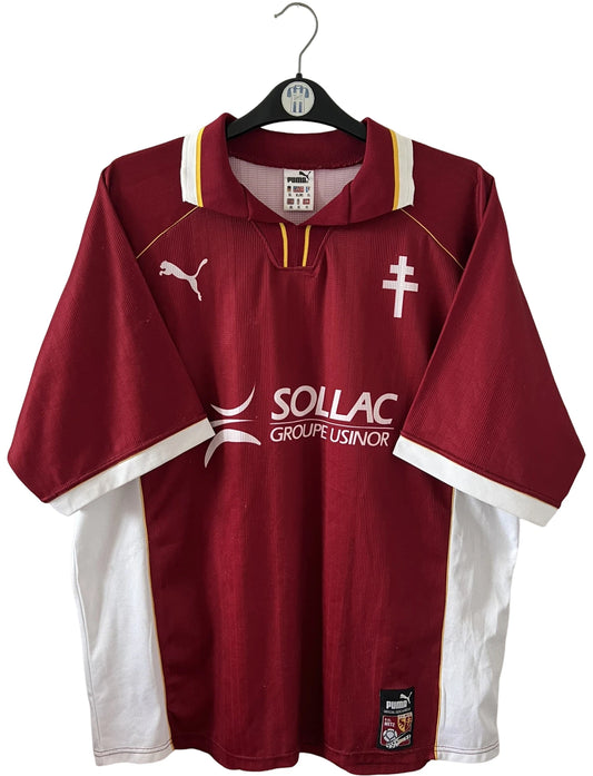 Maillot de foot vintage domicile rouge et blanc du FC Metz de la saison 1998/1999. On peut retrouver l'équipementier Puma et le sponsor Sollac. Le maillot est floqué du numéro 14 Geoffray Toyes. Il s'agit d'un maillot authentique d'époque.