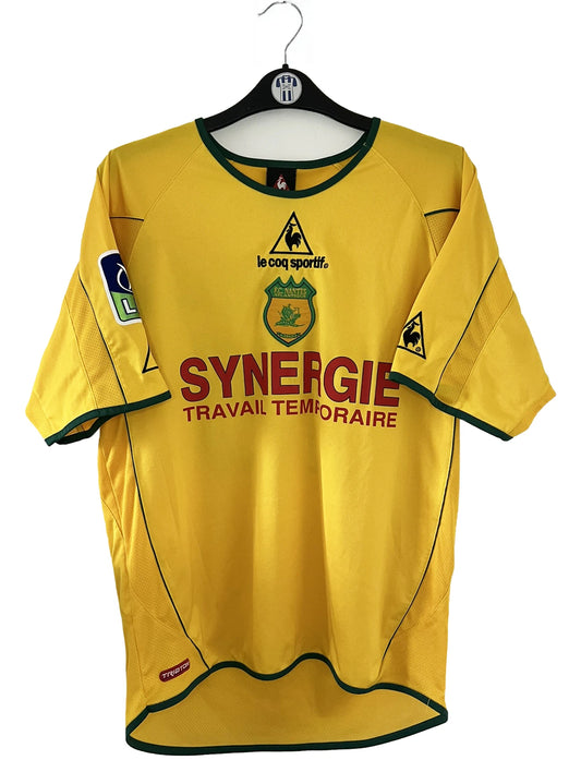 Maillot de foot vintage jaune domicile du FC Nantes de la saison 2003/2004. On peut retrouver l'équipementier Le Coq Sportif ainsi que le sponsor Synergie. Le maillot est floqué du numéro 19 Vahirua. Il s'agit d'un maillot authentique d'époque.