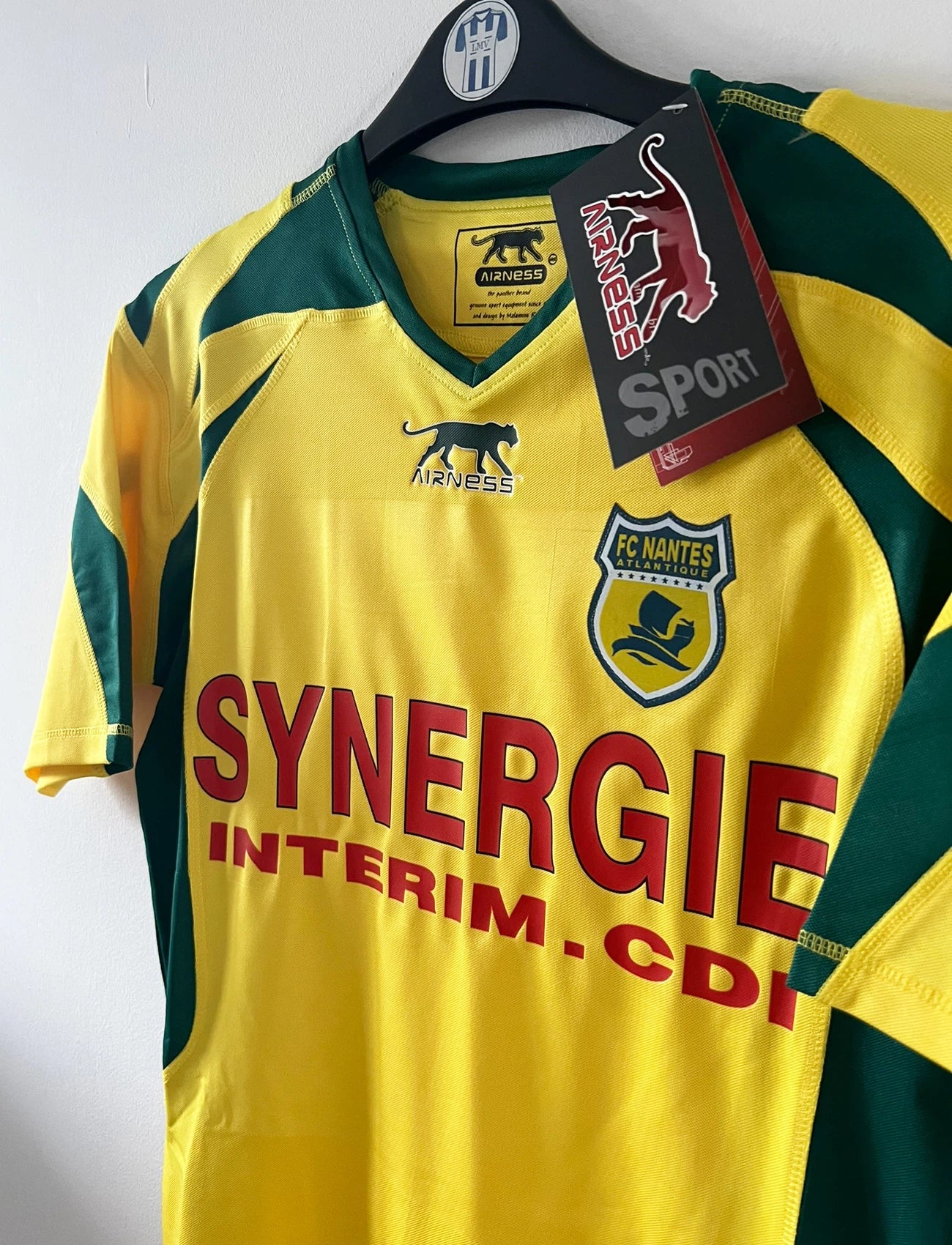 Maillot de foot vintage domicile jaune et vert du FC Nantes de la saison 2006/2007. On peut retrouver l'équipementier Airness et le sponsor Synergie. Il s'agit d'un maillot authentique d'époque.