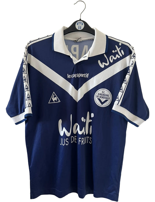Maillot de foot vintage domicile bleu et blanc des girondins de bordeaux de la saison 1996/1997. On peut retrouver l'équipementier Le Coq Sportif et le sponsor Waïti. Le maillot est floqué du numéro 27 Papin. Il s'agit d'un maillot authentique d'époque.