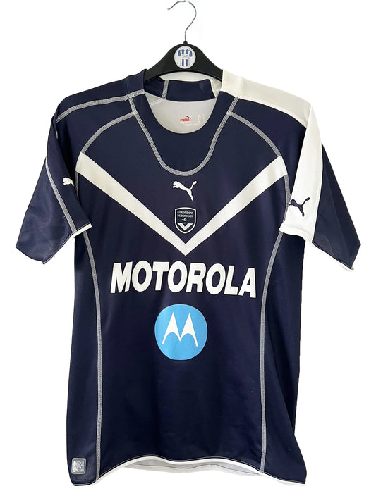 Maillot de foot vintage domicile bleu des Girondins de Bordeaux de la saison 2004-2005. On peut retrouver l'équipementier Puma et le sponsor Motorola. Le maillot est floqué du numéro 24 Mavuba. Il s'agit d'un maillot authentique d'époque.