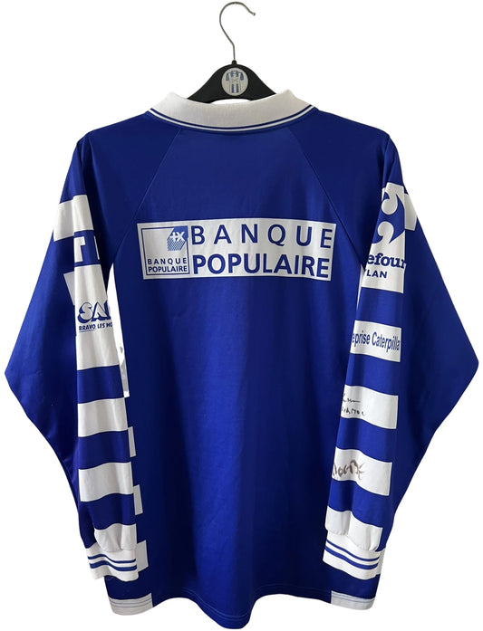 Maillot de foot vintage domicile bleu et blanc de Grenoble de la saison 1999/2000. On peut retrouver l'équipementier Duarig et l'équipementier Sodexho. Il s'agit d'un maillot authentique d'époque.