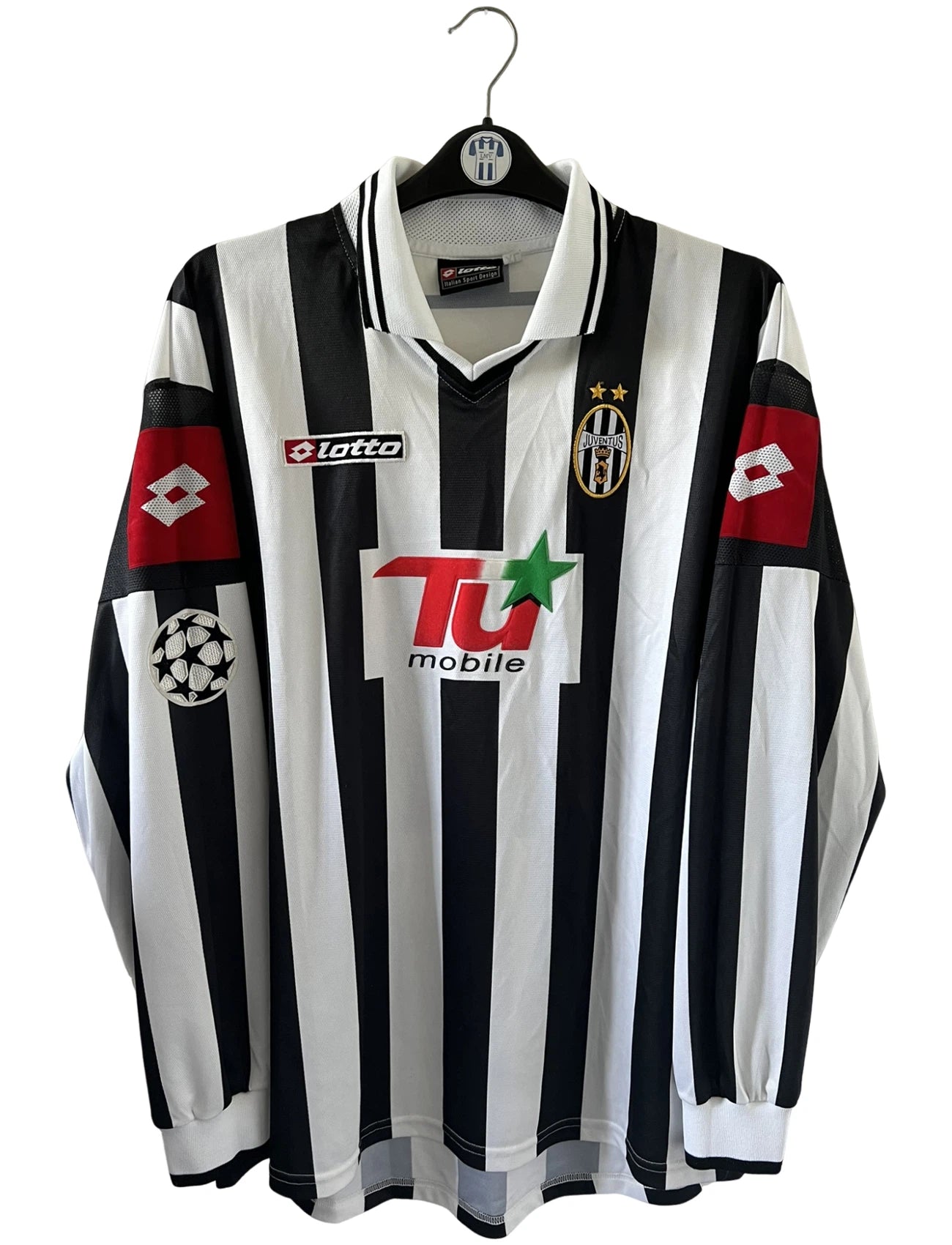 Maillot de foot vintage domicile noir et blanc de la juventus de la saison 2001/002. On peut retrouver l'équipementier Lotto et le sponsor TU Mobile. Il s'agit d'un maillot authentique d'époque, issu du stock pro de la juventus en version Ligue des Champions