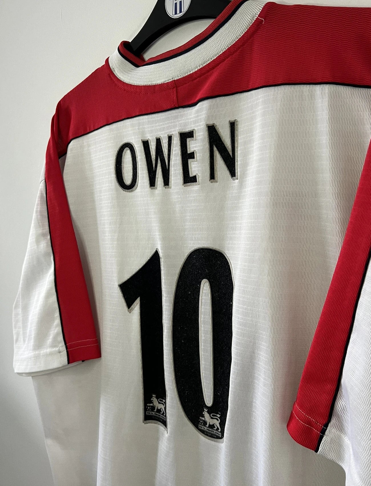 Maillot foot vintage extérieur liverpool blanc et rouge de la saison 1999/2000. On peut retrourver l'équipementier reebok et le sponsor carlsberg. Le maillot est floqué du numéro 10 Michael Owen. Il s'agit d'un maillot authentique d'époque.