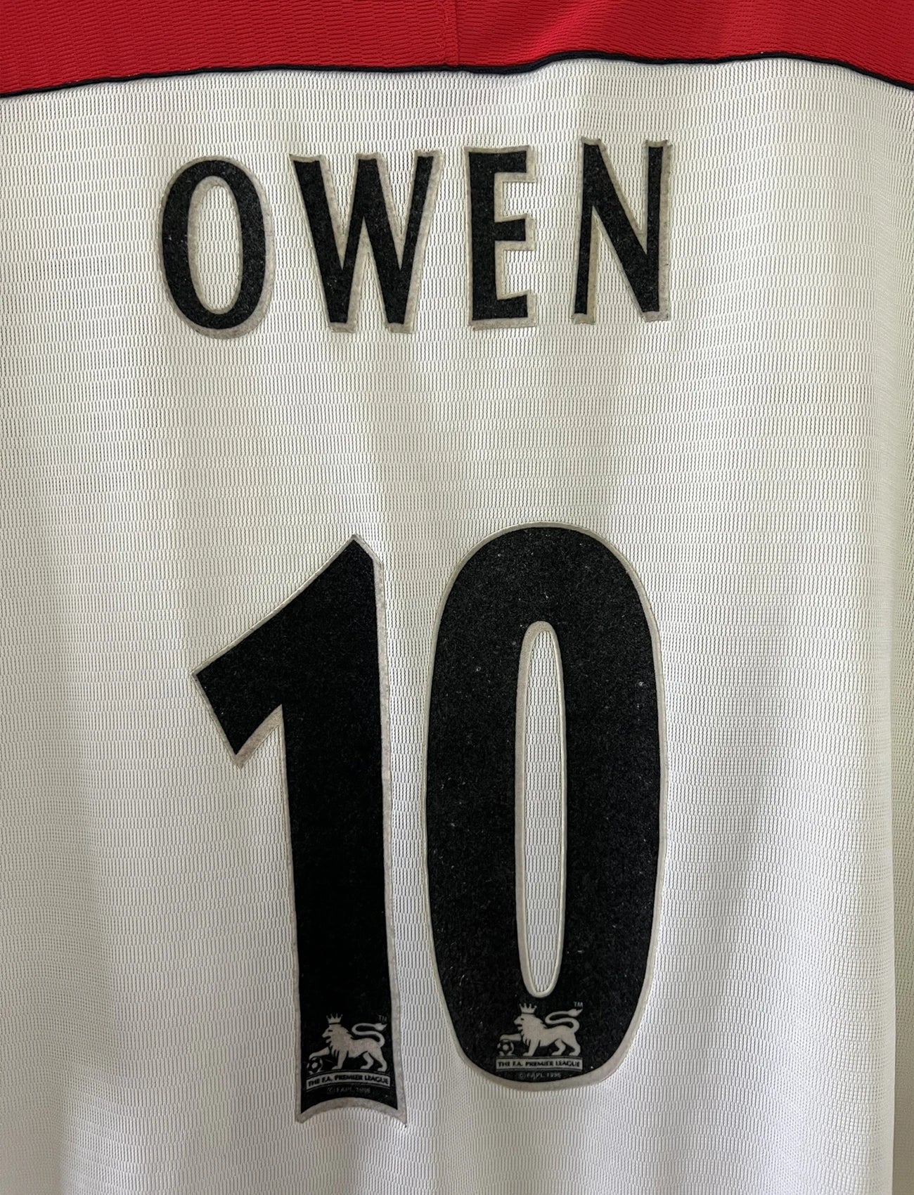 Maillot foot vintage extérieur liverpool blanc et rouge de la saison 1999/2000. On peut retrourver l'équipementier reebok et le sponsor carlsberg. Le maillot est floqué du numéro 10 Michael Owen. Il s'agit d'un maillot authentique d'époque.