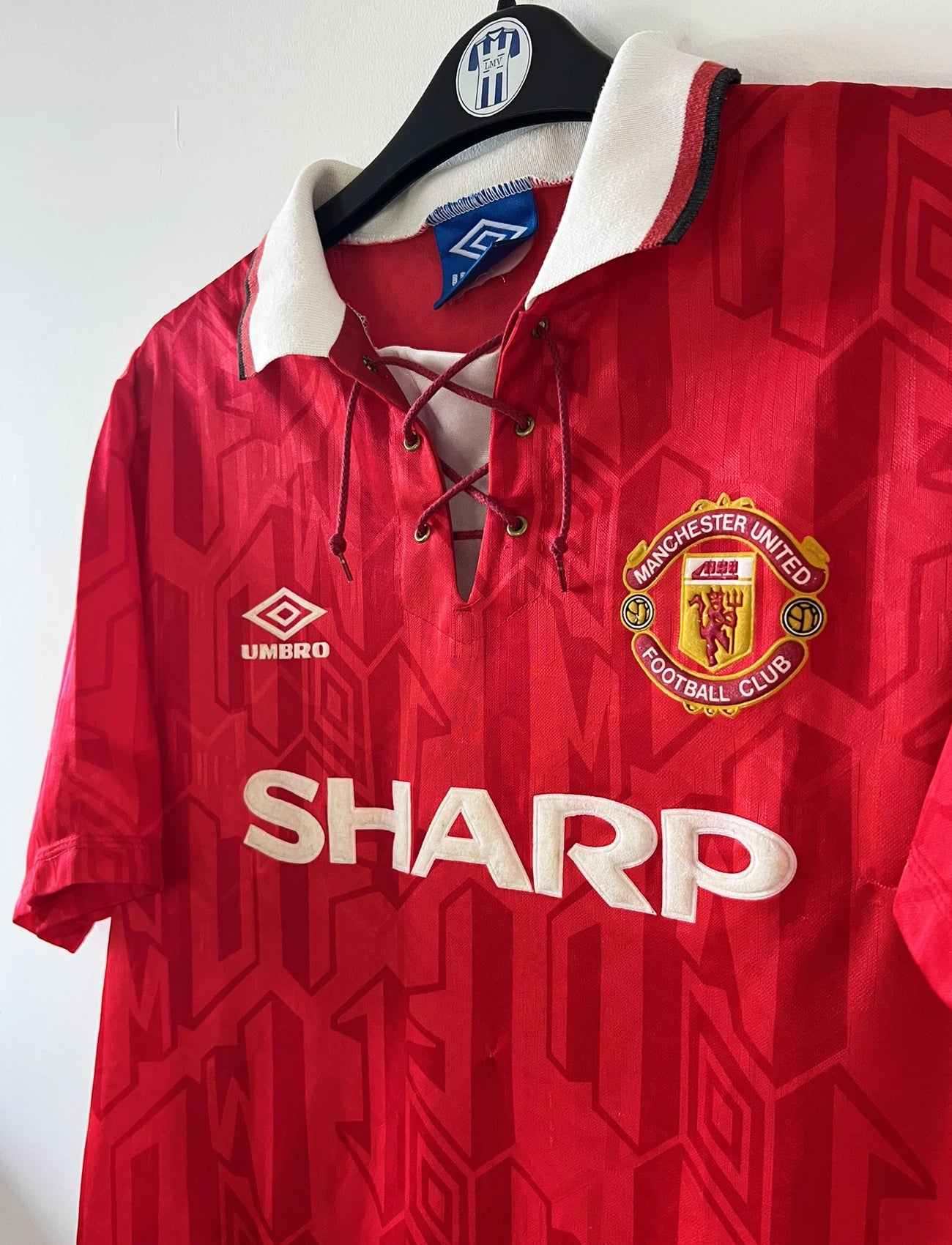 Maillot de foot vintage domicile rouge de Manchester United de la saison 1992/1994. On peut retrouver l'équipementier Umbro et le sponsor Sharp. Il s'agit d'un maillot authentique d'époque.
