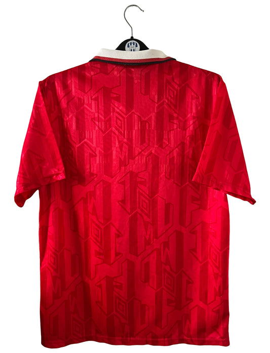 Maillot de foot vintage domicile rouge de Manchester United de la saison 1992/1994. On peut retrouver l'équipementier Umbro et le sponsor Sharp. Il s'agit d'un maillot authentique d'époque.