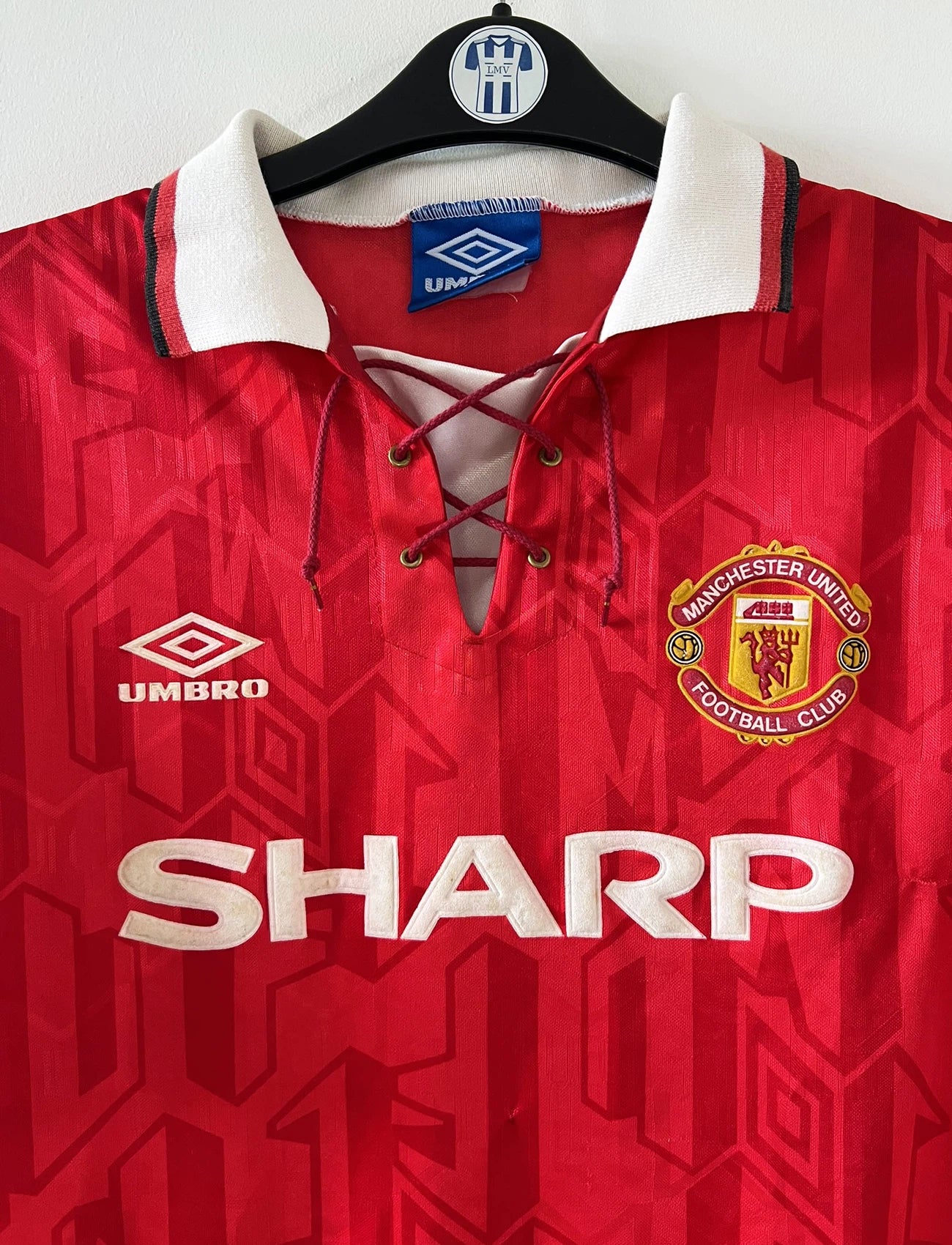 Maillot de foot vintage domicile rouge de Manchester United de la saison 1992/1994. On peut retrouver l'équipementier Umbro et le sponsor Sharp. Il s'agit d'un maillot authentique d'époque.