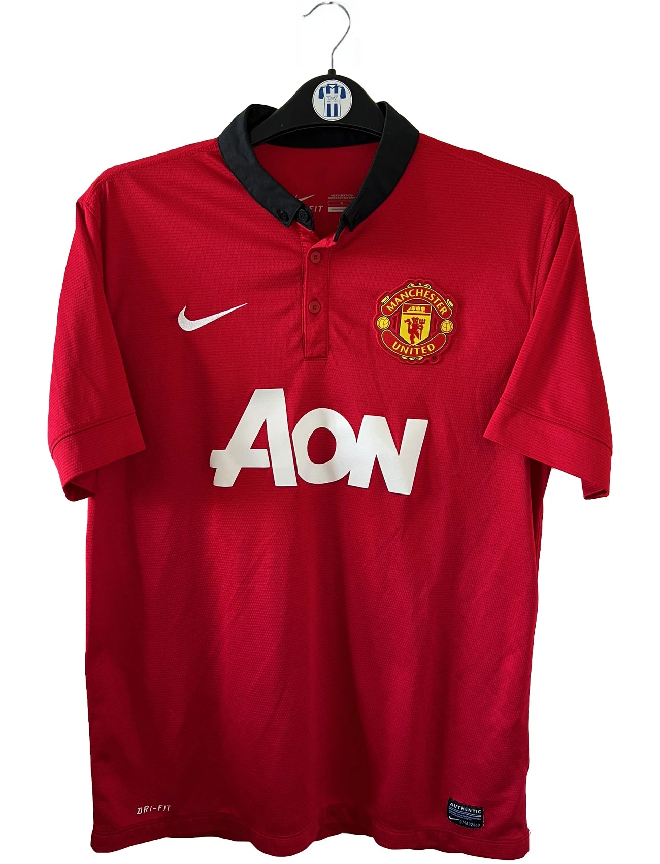Maillot de foot vintage domicile rouge et noir de manchester united de la saison 2013/14. On peut retrouver l'équipementier nike et le sponsor Aon. Il s'agit d'un maillot authentique comportant les numéros 532837-624