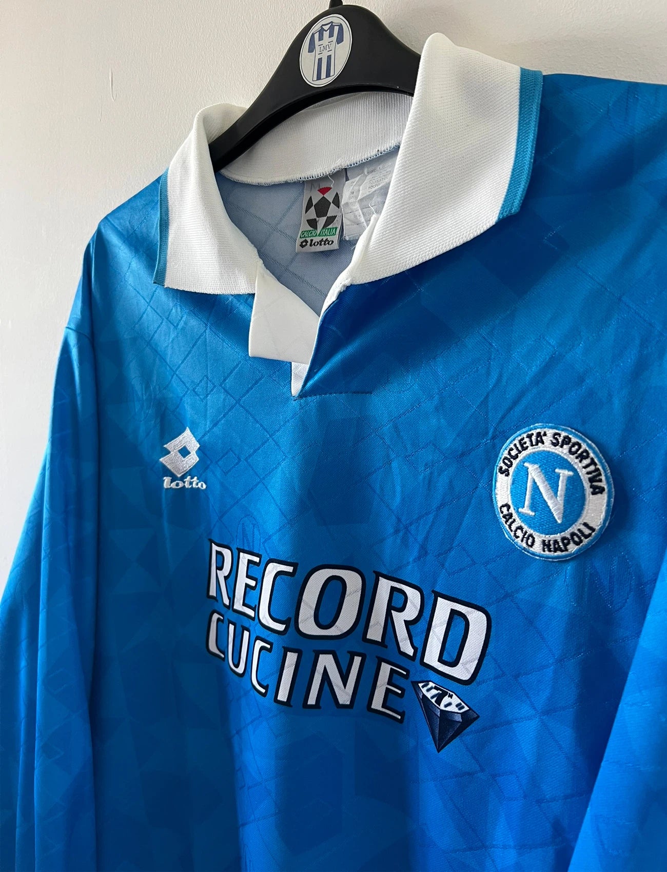 Maillot de foot vintage domicile bleu du Napoli de la saison 1994/1996. On peut retrouver l'équipementier Lotto et le sponsor Record Cucine. Il s'agit d'un maillot authentique d'époque.