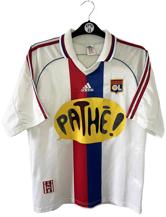 Maillot de foot vintage domicile blanc de l'OL de la saison 1999/2000. On peut retrouver l'équipementier adidas et le sponsor pathé. Le maillot est floqué du numéro 9 Sonny Anderson. Il s'agit d'un maillot authentique d'époque.