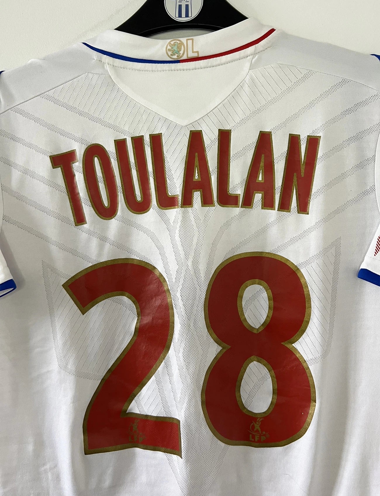Maillot de foot vintage domicile blanc de l'OL de la saison 2008/2009. On peut retrouver l'équipementier umbro et le sponsor novotel. Le maillot est floqué du numéro 28 Jérémy Toulalan. Il s'agit d'un maillot authentique d'époque.