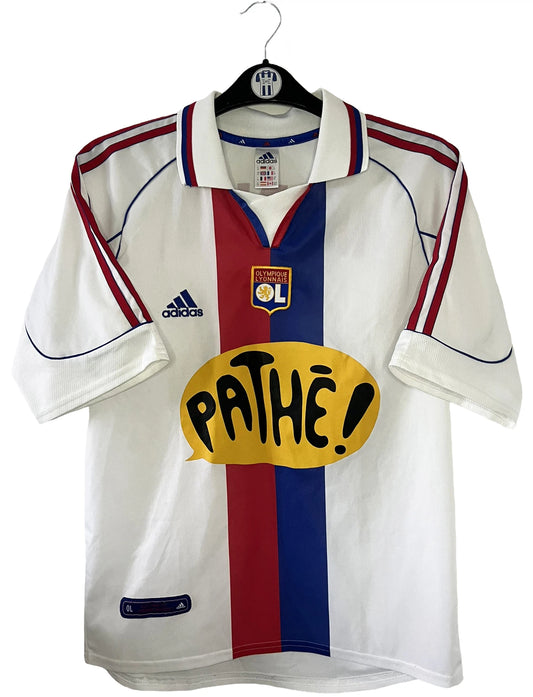 Maillot de foot vintage domicile blanc de l'Olympique Lyonnais de la saison 1999-2000. On peut retrouver l'équipementier Adidas et le sponsor Pathé. Le maillot est floqué du numéro 7 Steve Marlet. Il s'agit d'un maillot authentique d'époque comportant les numéros 683485