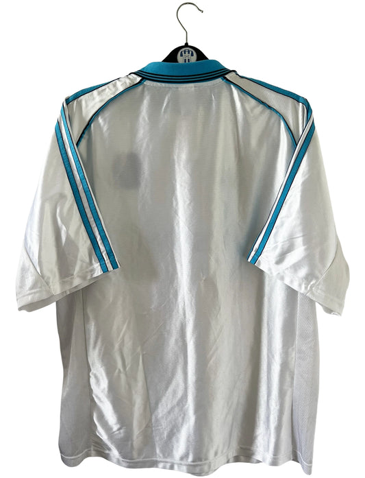 Maillot de foot vintage domicile blanc et bleu de l'OM de la saison 1998-1999. On peut retrouver l'équipementier Adidas et le sponsor Ericsson. Il s'agit d'un maillot authentique d'époque.