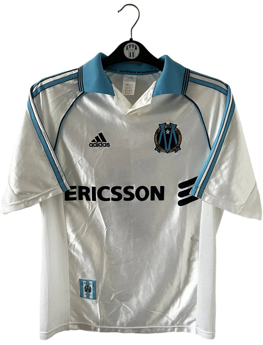 Maillot de foot vintage domicile de l'OM de la saison 1998/1999. On peut retrouver l'équipementier Adidas et le sponsor Ericsson. Le maillot est floqué du numéro 7 Robert Pirès. Il s'agit d'un maillot authentique d'époque.