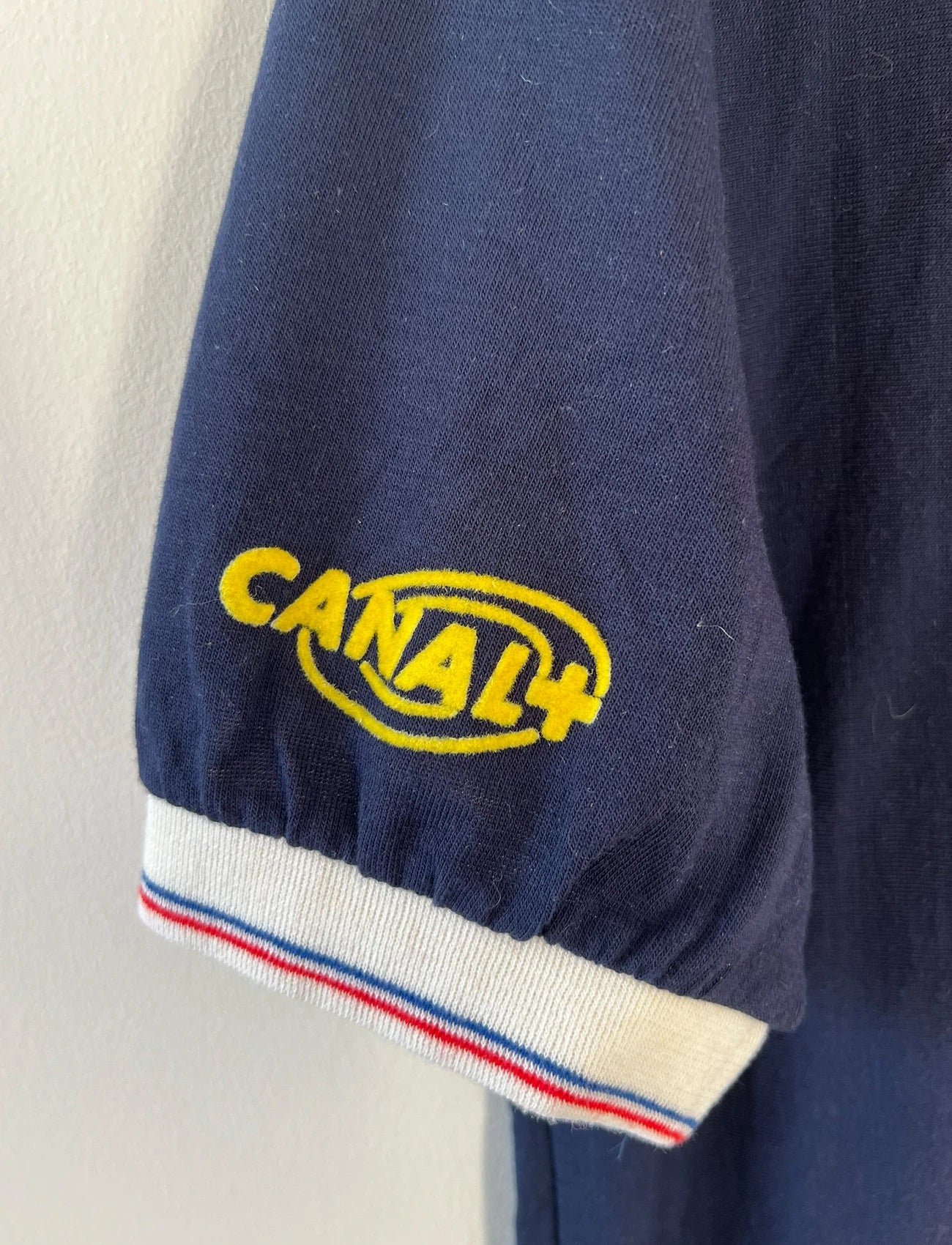 Maillot de foot vintage domicile bleu et rouge du PSG de la saison 1987/1988. On peut retrouver l'équipementier Adidas et le sponsor RTL, Canal + et La Cinq. Il s'agit d'un maillot authentique d'époque.