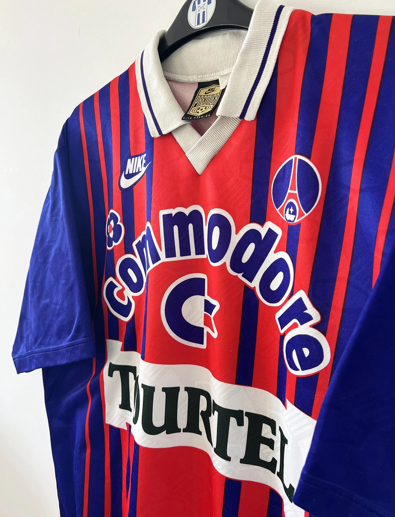 Maillot vintage domicile rouge et bleu du PSG de la saison 1993/1994. On peut retrouver l'équipementier nike, le sponsor commodore et le sponsor tourtel. Il s'agit d'un maillot authentique d'époque.