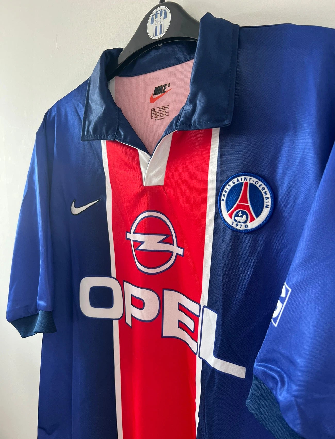 Maillot de foot vintage domicile bleu avec la bande hechter du PSG de la saison 1998/1999. On peut retrouver l'équipementier Nike et le sponsor Opel. Il s'agit d'un maillot authentique d'époque.