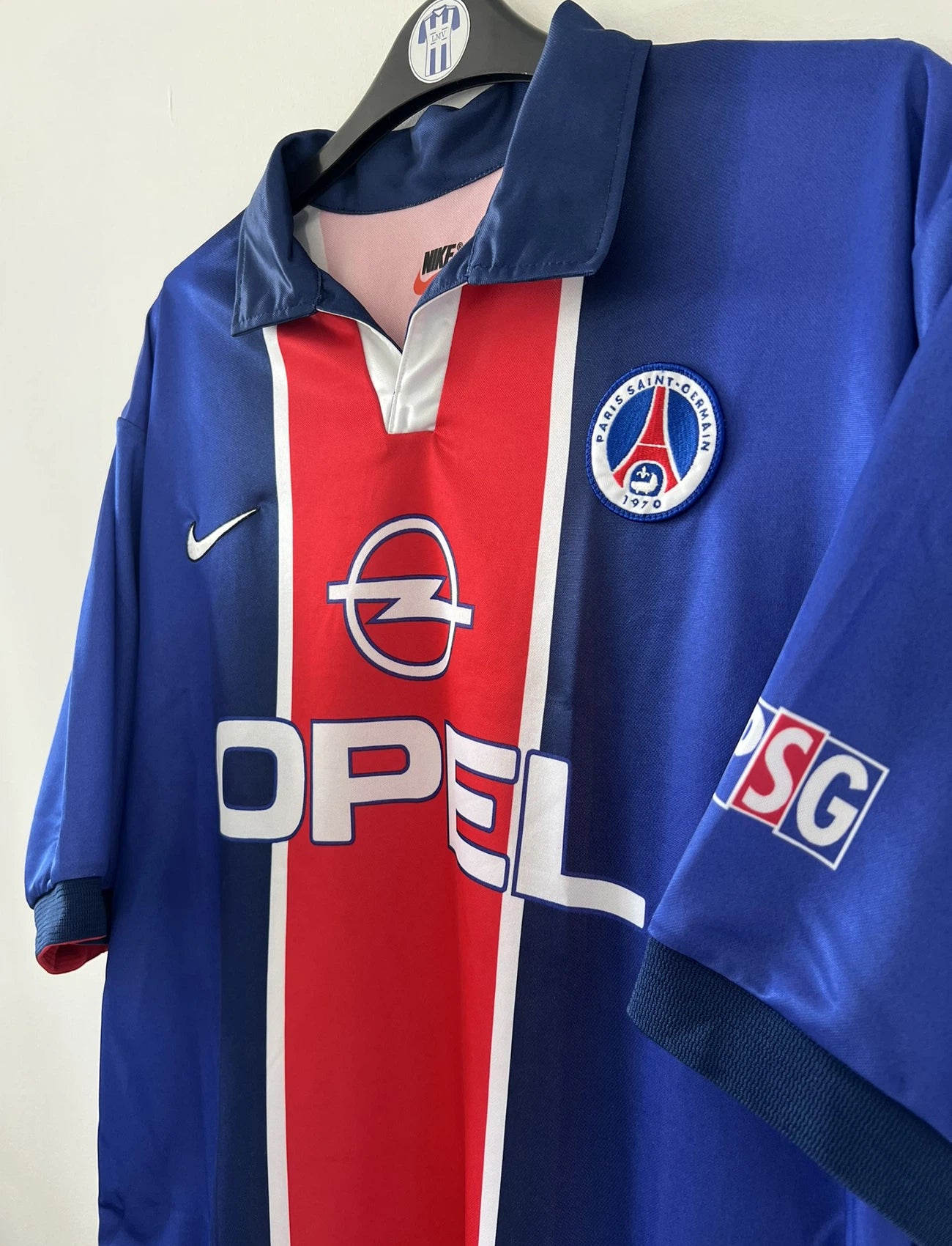 Maillot de foot vintage domicile du PSG de la saison 1998/1999. Le maillot est de couleur bleu blanc et rouge. On peut retrouver l'équipementier nike et le sponsor opel. Il s'agit d'un maillot authentique d'époque.