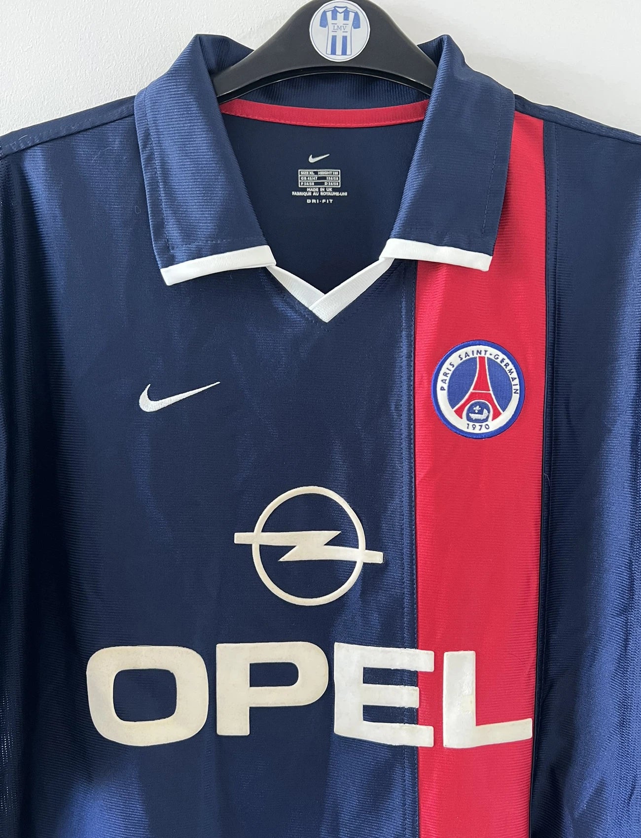 Maillot de foot vintage domicile bleu rouge et blanc du PSG de la saison 2001/2002. On peut retrouver l'équipementier nike et le sponsor Opel. Il s'agit d'un maillot authentique d'époque.