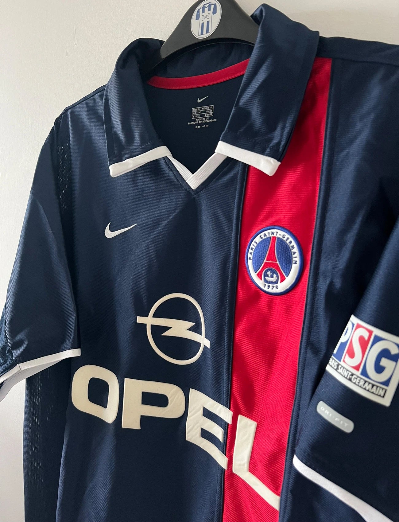 Maillot de foot vintage domicile bleu du PSG de la saison 2001/2002. On peut retrouver l'équipementier Nike et le sponsor Opel. Il s'agit d'un maillot authentique d'époque.
