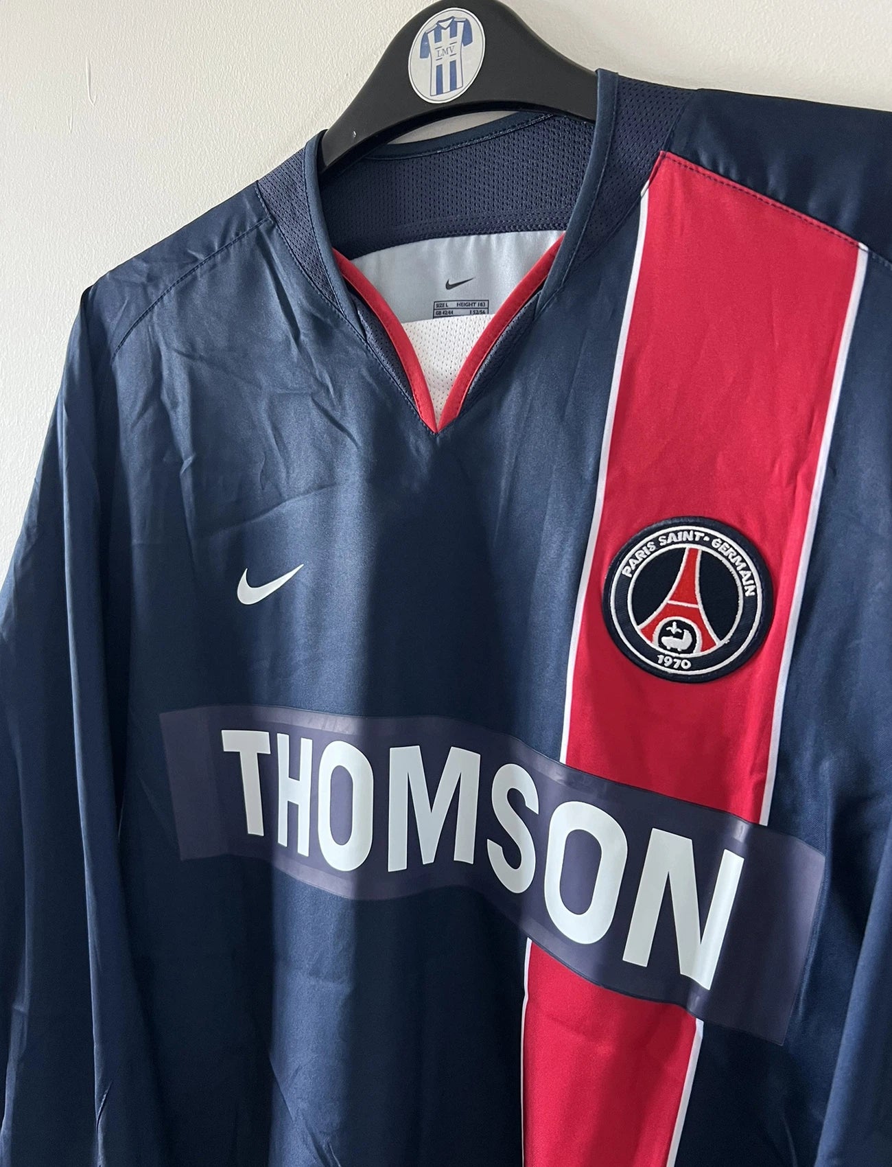 Maillot de foot vintage domicile bleu et rouge issu du stock pro du PSG. Il s'agit du maillot de la saison 2003/2004. On peut retrouver l'équipementier Nike et le sponsor Thomson. Il s'agit d'un maillot authentique d'époque.