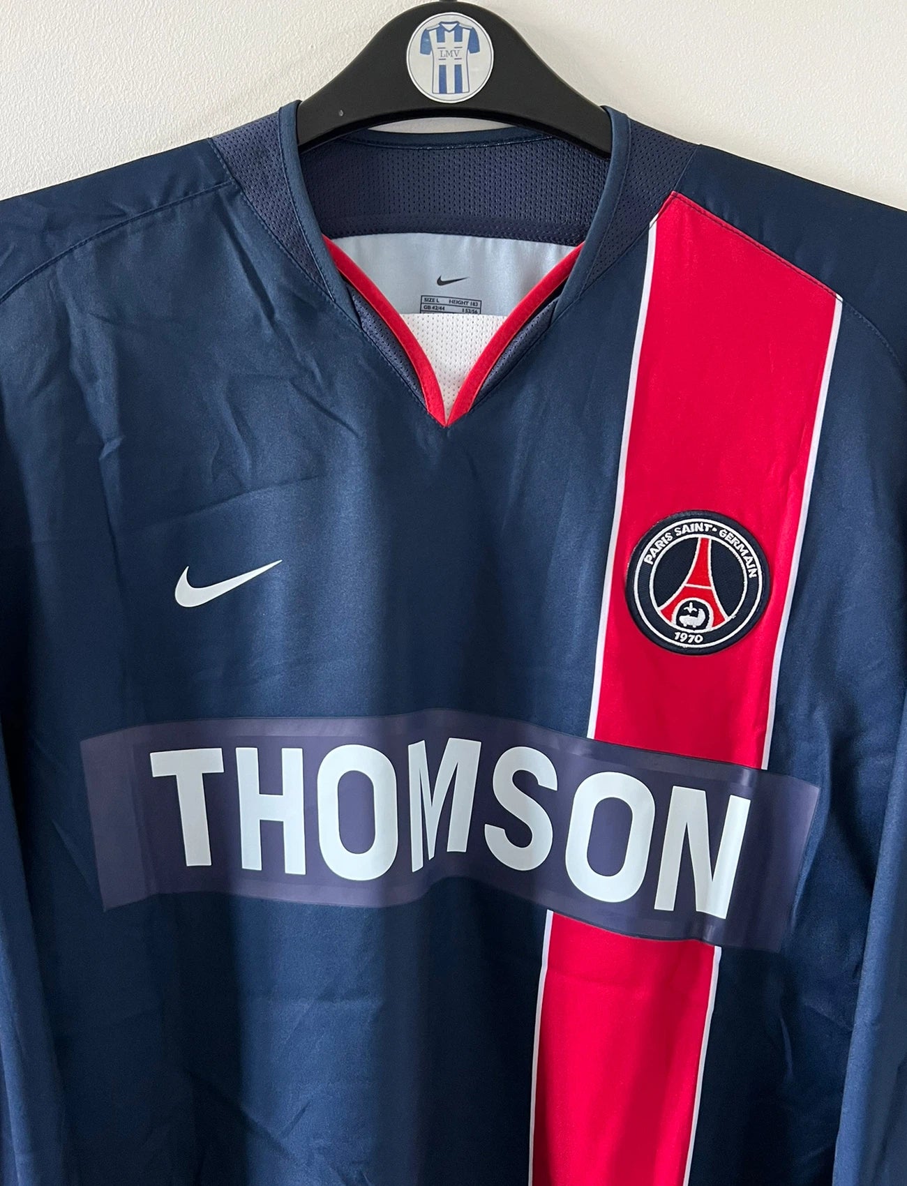 Maillot de foot vintage domicile bleu et rouge issu du stock pro du PSG. Il s'agit du maillot de la saison 2003/2004. On peut retrouver l'équipementier Nike et le sponsor Thomson. Il s'agit d'un maillot authentique d'époque.