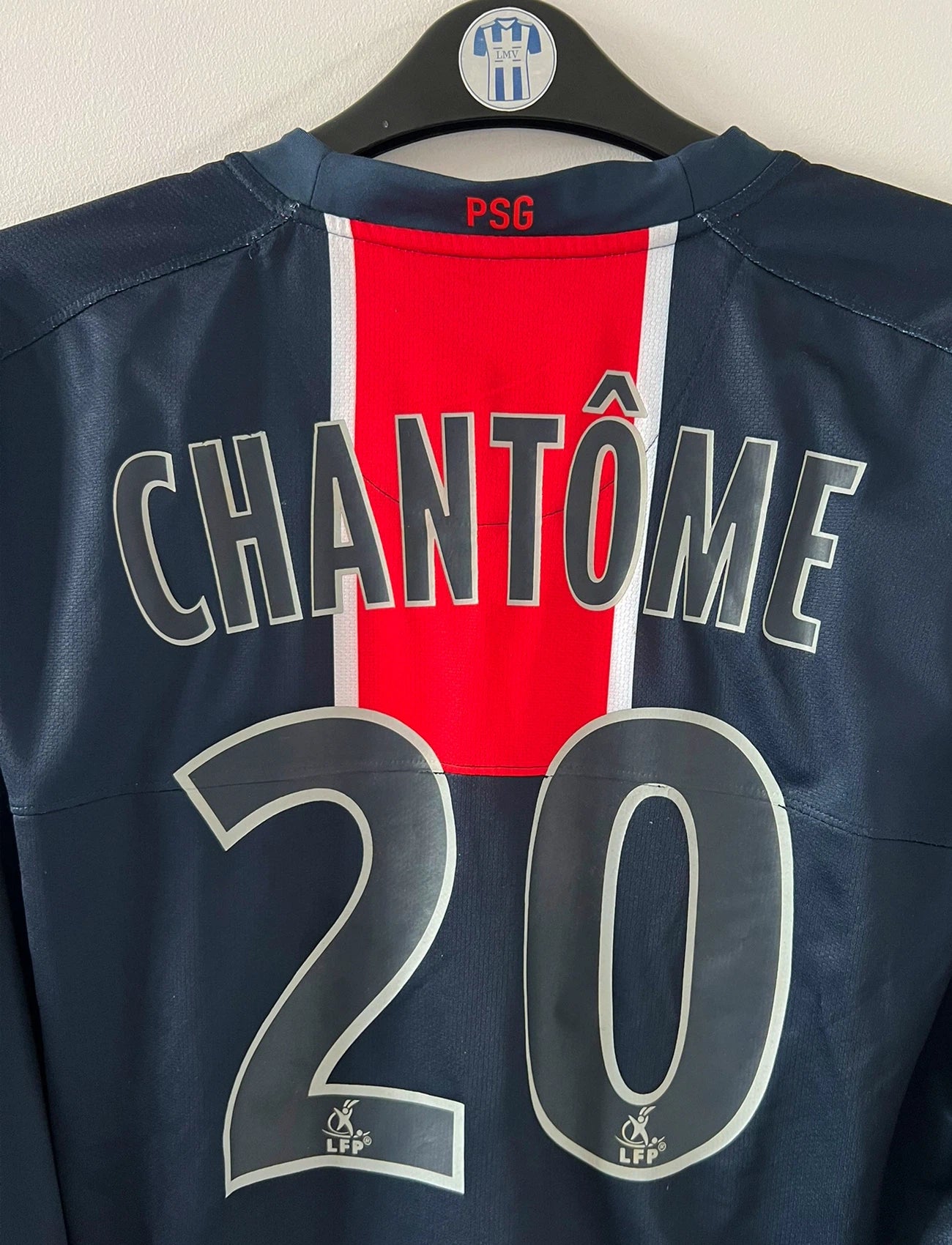 Maillot de foot vintage domicile bleu et rouge du PSG de la saison 2006/2007. On peut retrouver l'équipementier Nike et le sponsor Fly Emirates. Le Maillot est floqué du numéro 20 Chantôme. Il s'agit d'un maillot authentique d'époque.