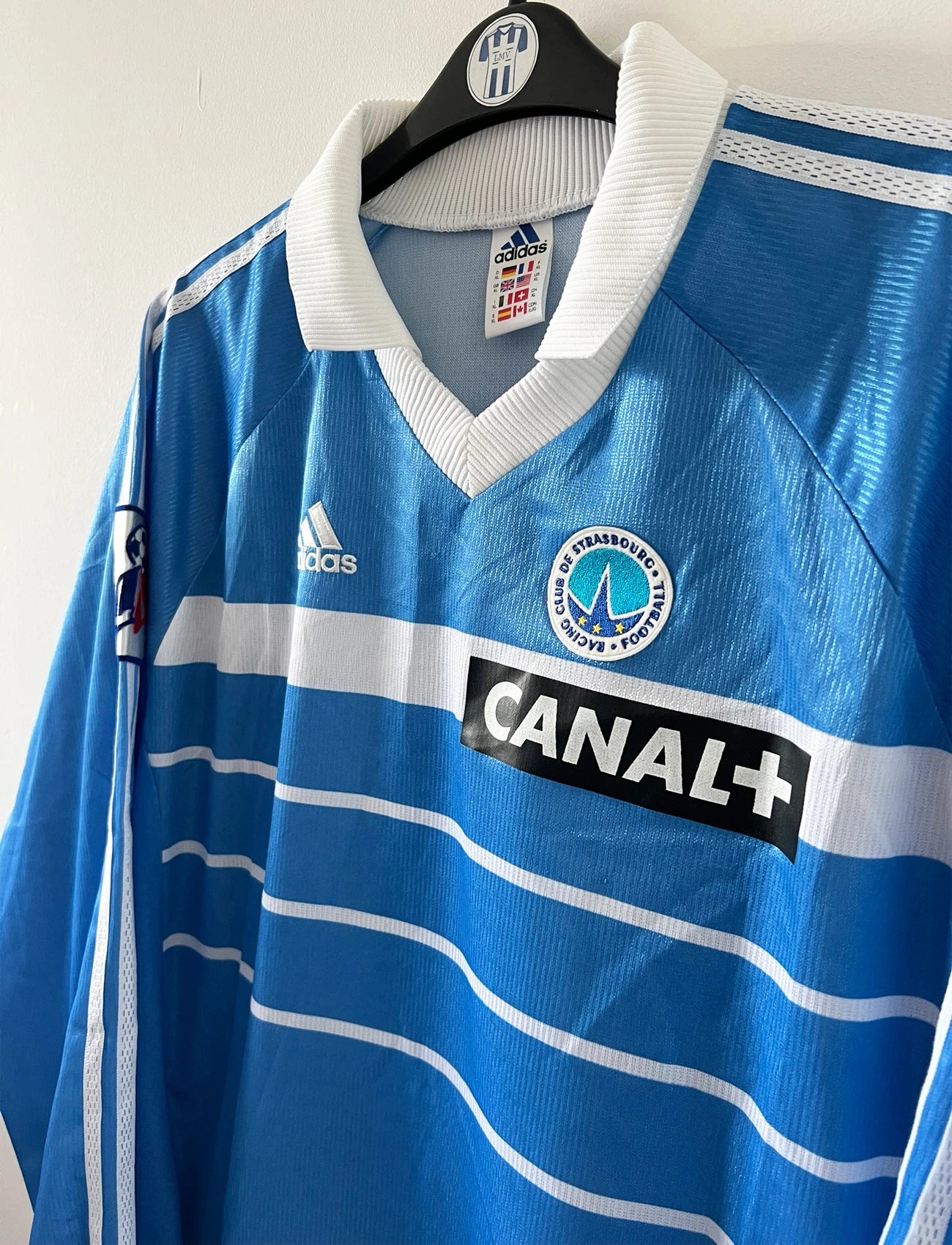 Maillot de foot vintage domicile bleu de strasbourg de la saison 1999/2000. On peut retrouver l'équipementier Adidas et le sponsor Canal+. Il s'agit d'un maillot authentique d'époque, issu du stock pro du club