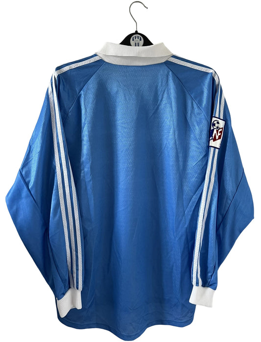 Maillot de foot vintage domicile bleu de strasbourg de la saison 1999/2000. On peut retrouver l'équipementier Adidas et le sponsor Canal+. Il s'agit d'un maillot authentique d'époque, issu du stock pro du club